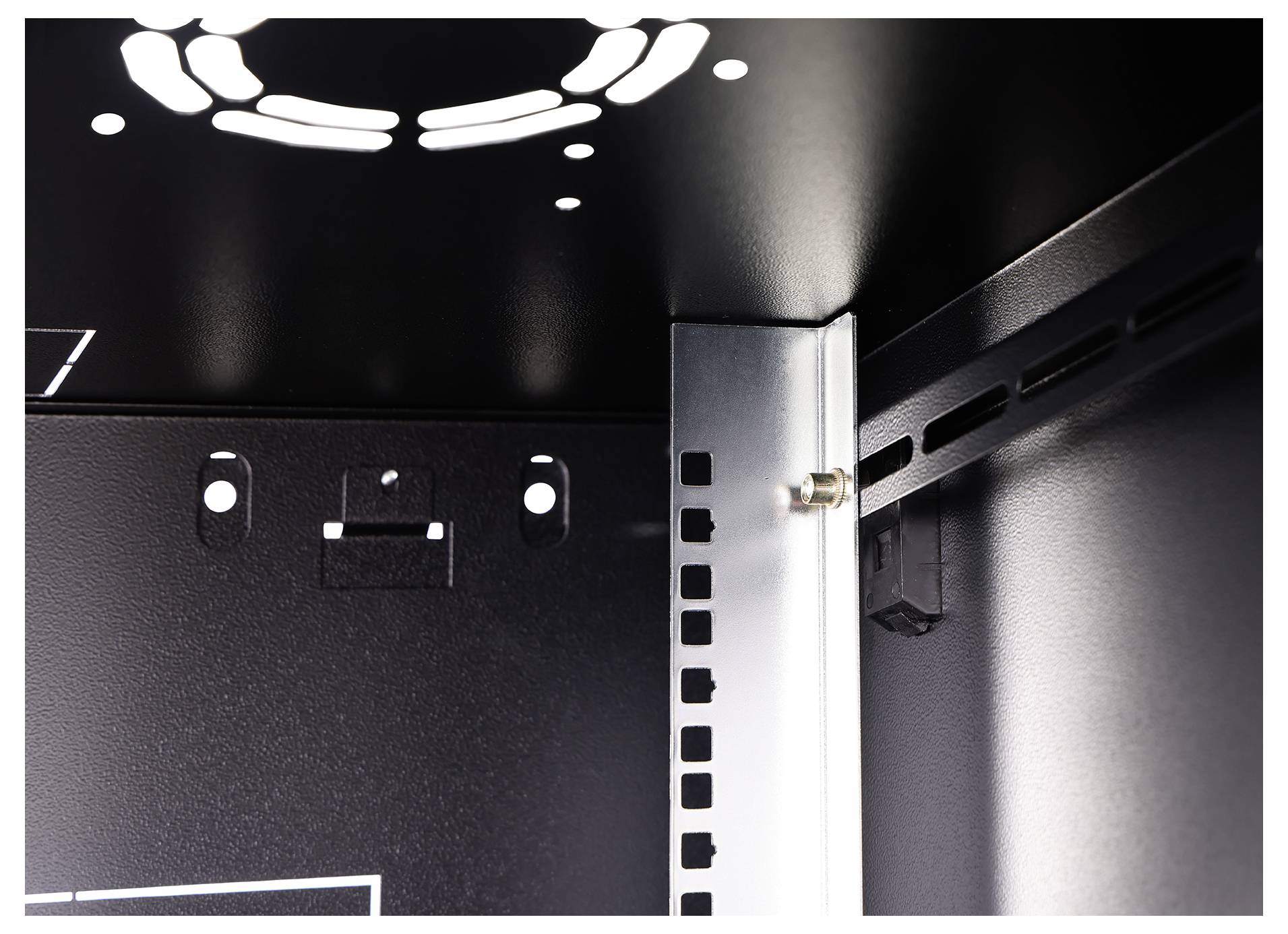 Innenansicht eines Metallschranks mit einer Montageschiene, die Löcher zur Befestigung von elektronischen Komponenten aufweist.