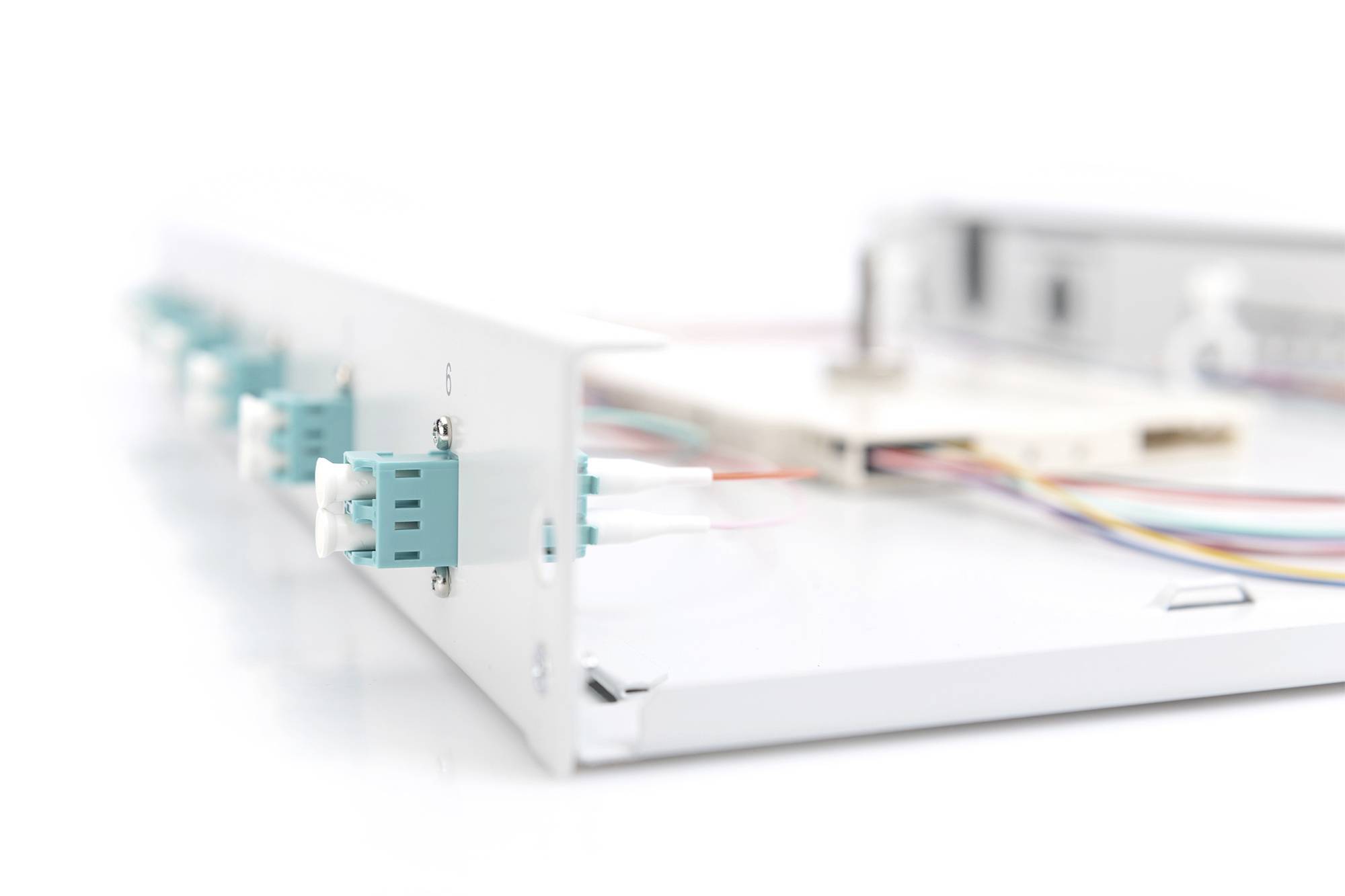 Ein offenes Glasfaser-Patchpanel mit mehreren farbigen Kabeln, die an Anschlüsse angeschlossen sind.