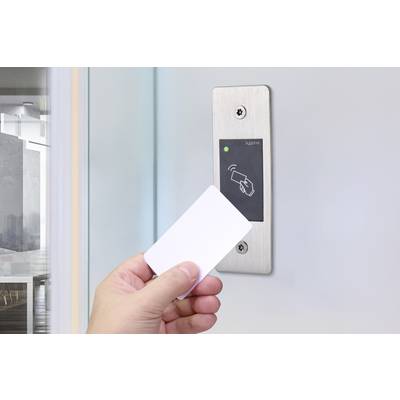Eine Hand hält eine Keycard vor einen Wandleser mit grünem Lichtsignal, in einem modernen Bürogebäude.