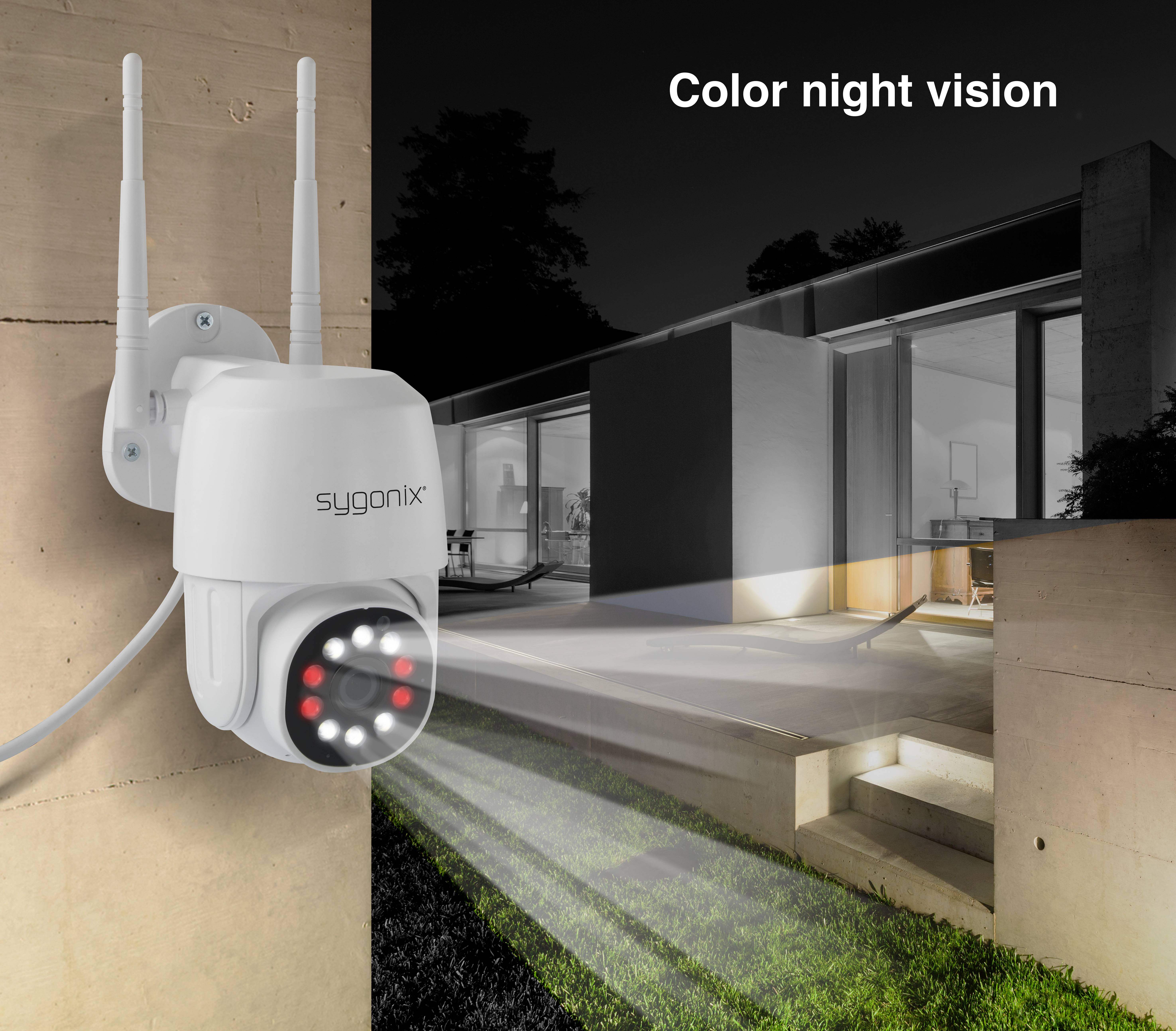 Überwachungskamera mit Nachtsichtfunktion zeigt farbige Bilder in der Dunkelheit. Haus und Garten im Hintergrund bei Nacht.