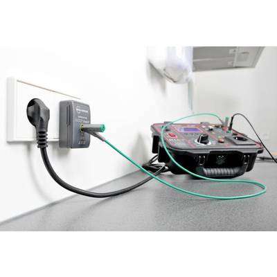 Ein Prüfgerät ist an eine Steckdose angeschlossen. Es testet elektrische Sicherheit und Leistung, angezeigt durch Kabel und Messanzeigen.