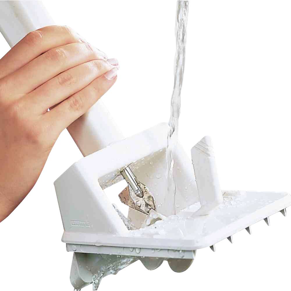 Wasser fließt über eine weiße Fliesenreinigungsbürste, die von einer Hand gehalten wird. Die Bürste hat feste Borsten.