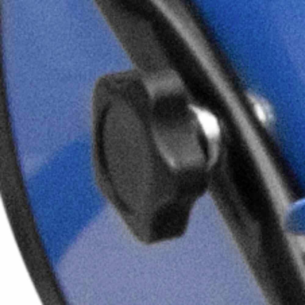 Ein blaues Metallobjekt mit einem schwarzen Drehknopf ermöglicht die Anpassung oder Befestigung. Hintergrund unscharf.