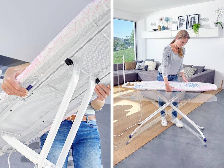 Eine Frau steht in einem Wohnzimmer und justiert die Höhe eines Bügelbretts. Im Hintergrund sind Pflanzen und gerahmte Bilder zu sehen.