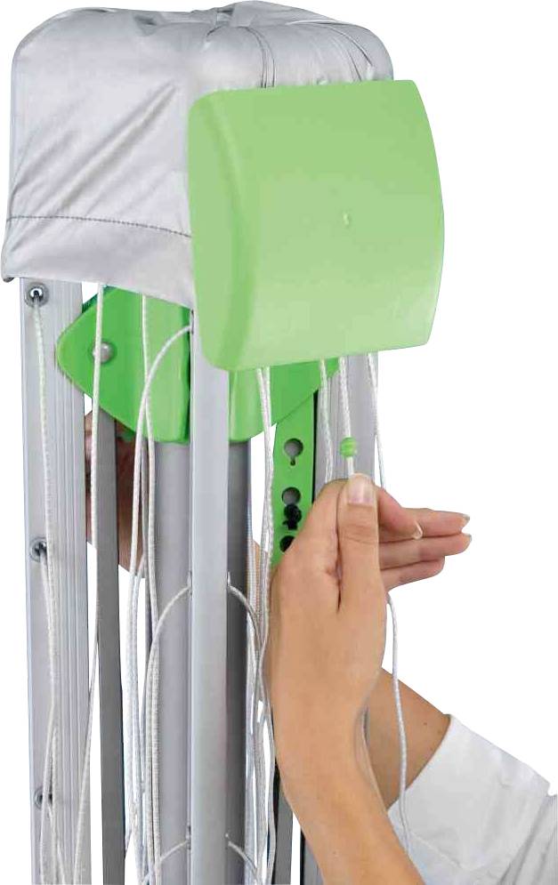 Eine Hand zieht an Seilen eines physiotherapeutischen Übungsgeräts mit grünem Widerstandselement. Gerät zur Rehabilitationstraining.