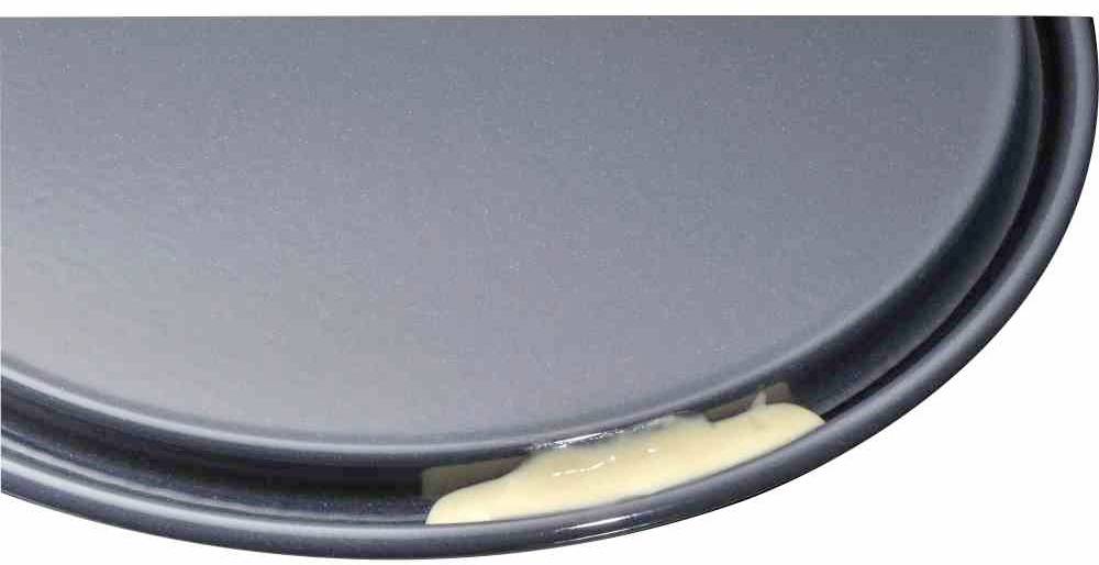 Eine rechteckige Backform mit flachem Rand hat eine Lücke, durch die roher Kuchenteig ausläuft.