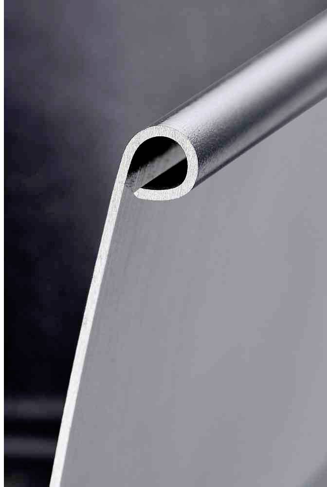 Nahaufnahme eines gebogenen Aluminiumblechs, das eine Kante und Struktur zeigt. Das Bild betont die Materialbeschaffenheit.