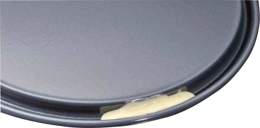 Ein graues Tablett mit einem hellen, cremigen Fleck am Rand, möglicherweise von verschüttetem Essen. Kein zusätzlicher Kontext ersichtlich.