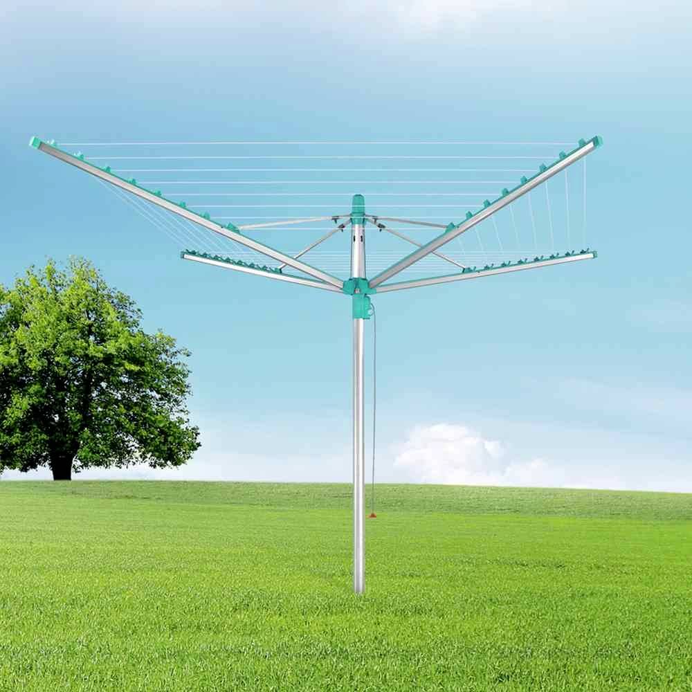 Wäschespinne auf einer grünen Wiese unter blauem Himmel neben einem Baum. Ideal zum Trocknen von Kleidung im Freien.