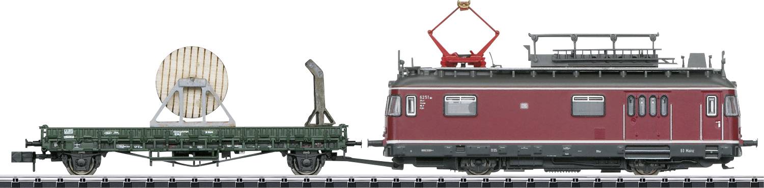 Modellbahnzug mit rotem Personenwagen und offenem Güterwagen, der eine große Kabeltrommel transportiert. Schienen im Vordergrund.