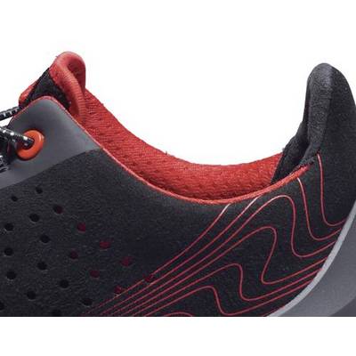 Nahaufnahme eines schwarz-roten Sportschuhs mit geschwungenen Linien auf der Seite. Der Innenschuh ist rot gefüttert.