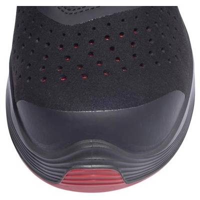 Ein schwarzer Schuh mit roten Akzentlinien an der Sohle und roten Details durch die Perforation auf der Oberseite sichtbar.