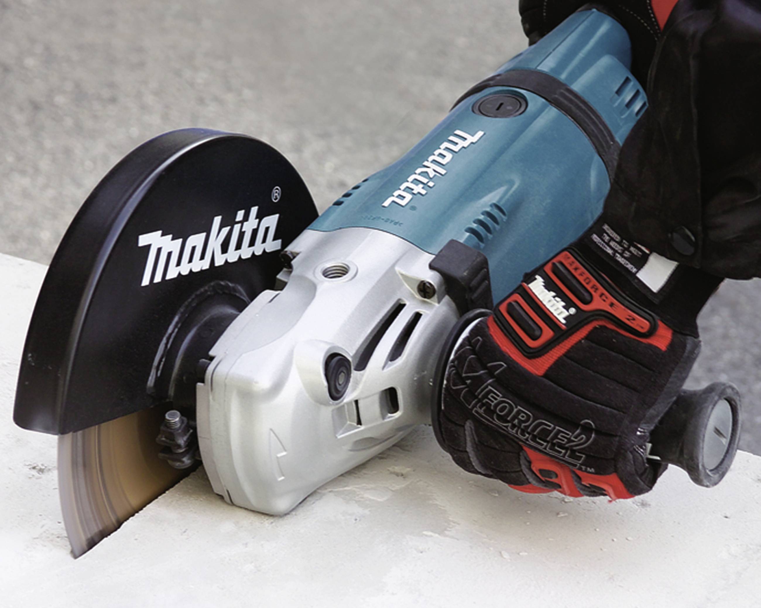 Eine Person schneidet Beton mit einer elektrischen Handkreissäge. Die Säge ist von der Marke Makita.