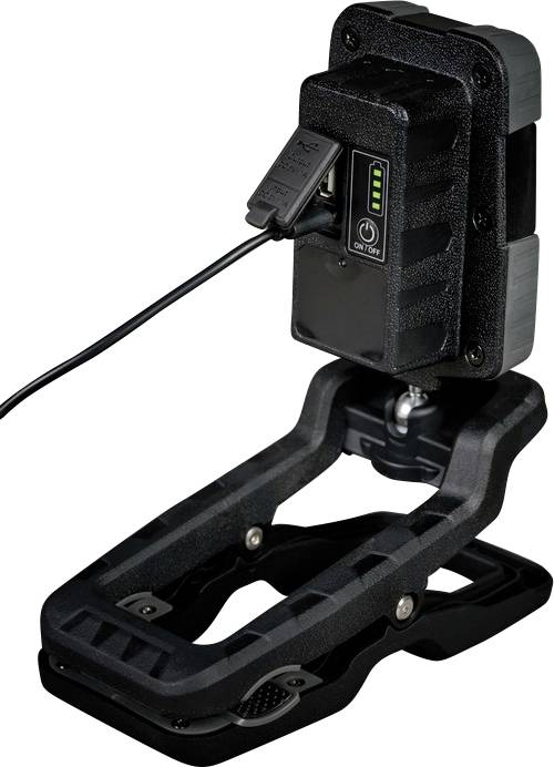 Ein tragbares Gerät in einer Halterung mit einem angeschlossenen Kabel und LED-Anzeige, zeigt den Ladezustand an.