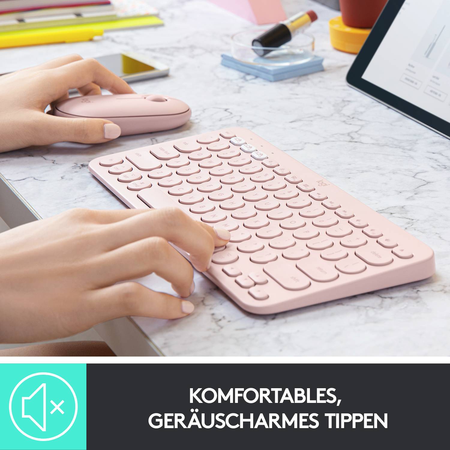 Person tippt leise auf einer rosa Tastatur neben einer rosa Maus. Text unten: 'Komfortables, geräuscharmes Tippen'.