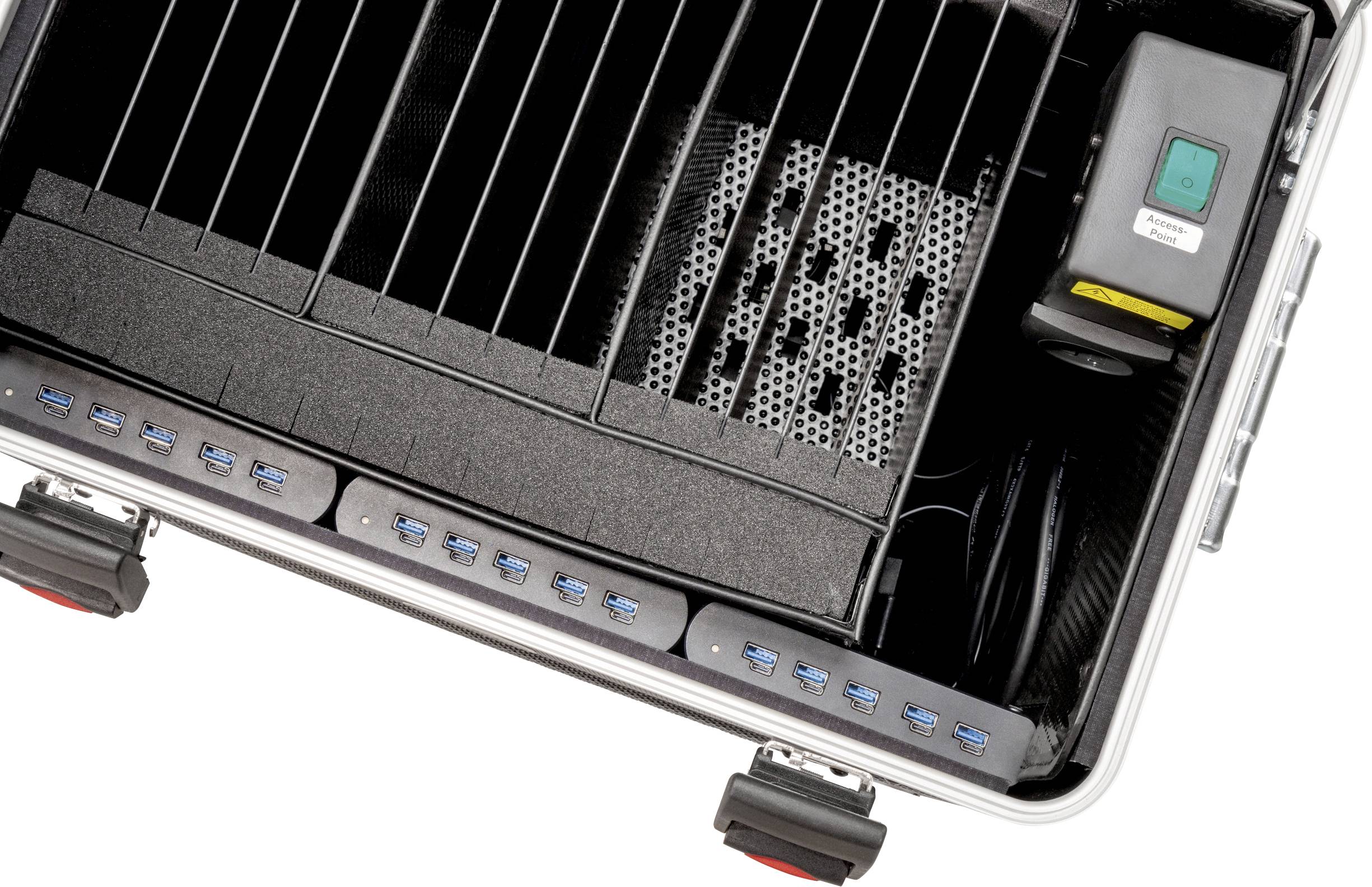 Ein offener Koffer zeigt mehrere USB-Anschlüsse und elektronische Komponenten. Ein grüner Einschaltknopf ist sichtbar.