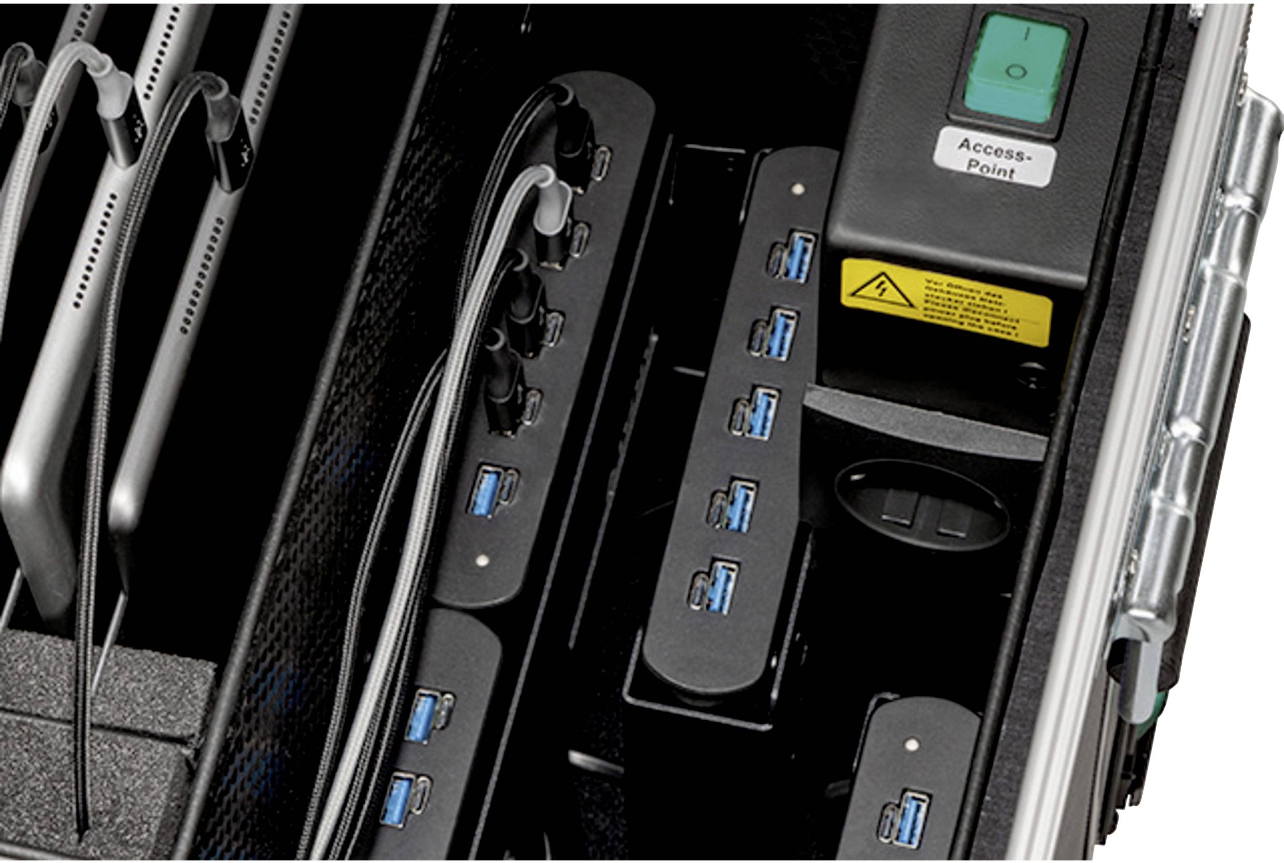 Mehrere Tablets sind in einer Ladestation mit USB-Anschlüssen organisiert. Ein Netzschalter und ein Bereich mit Kabeln sind sichtbar.