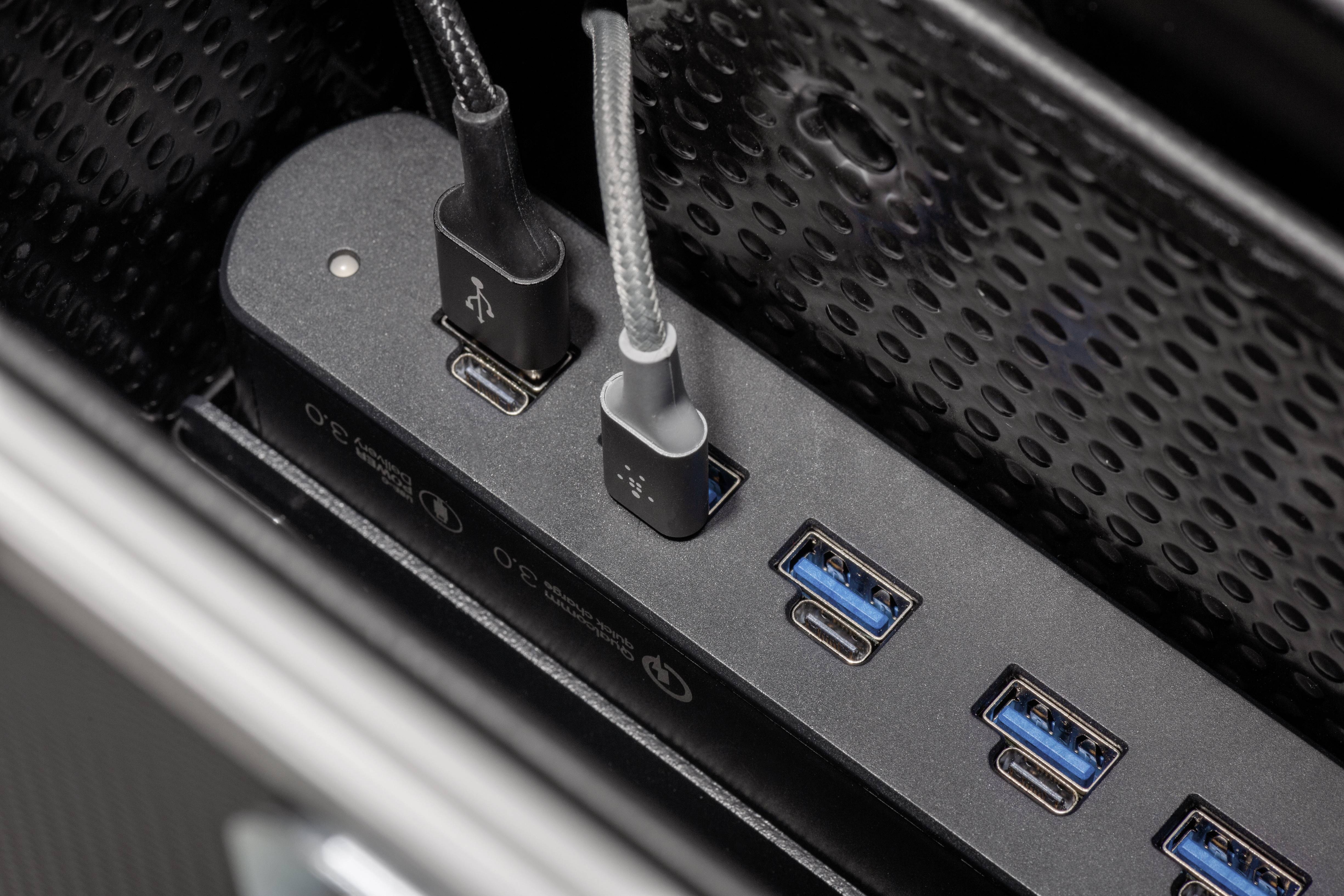 Ein USB-Hub mit mehreren Anschlüssen: zwei USB-C-Kabel sind eingesteckt, daneben vier weitere USB-A-Anschlüsse.