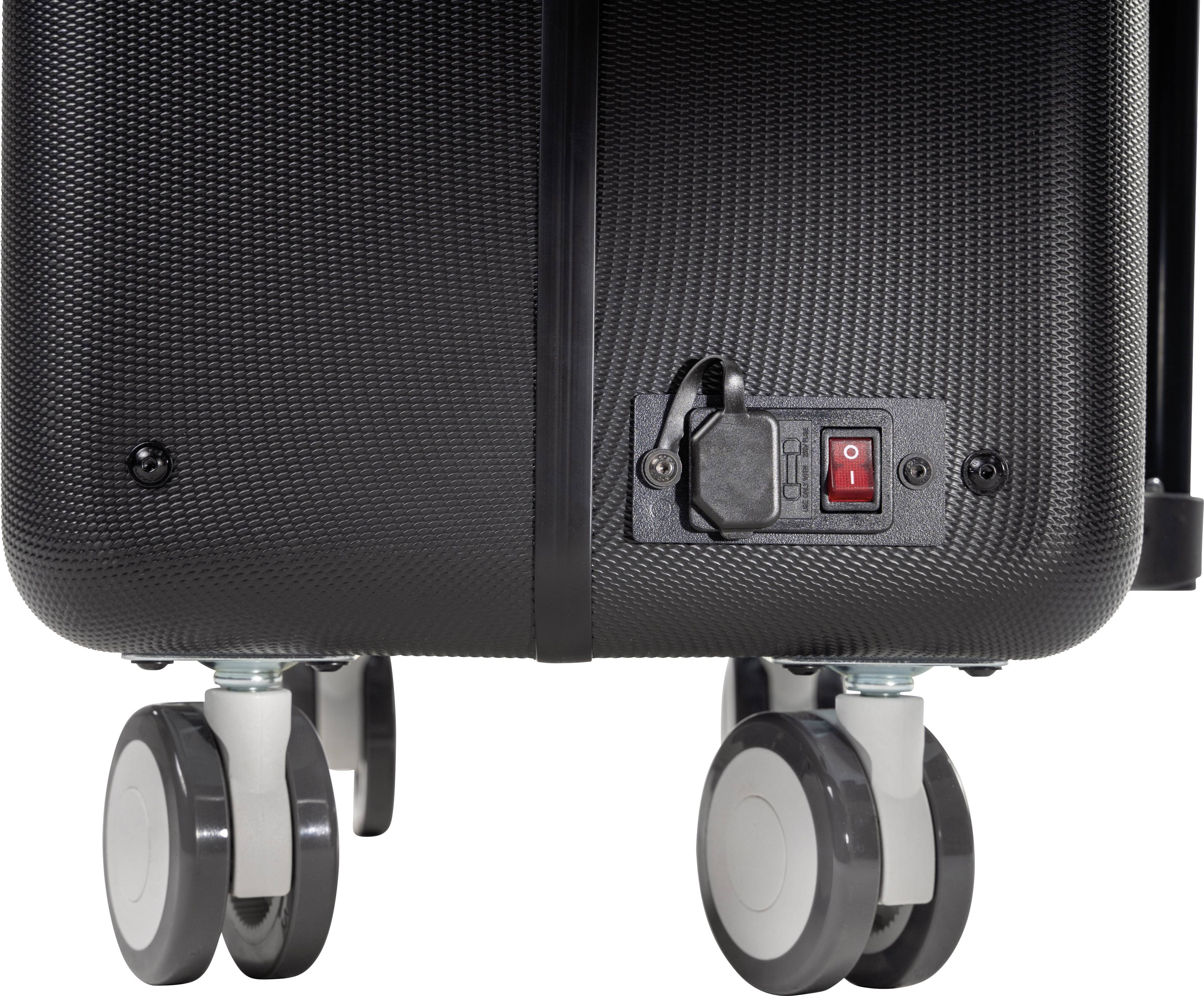 Rückseite eines schwarzen Koffers mit vier Rollen, zeigt einen An-/Aus-Schalter mit Abdeckung und Anschlussbuchse.