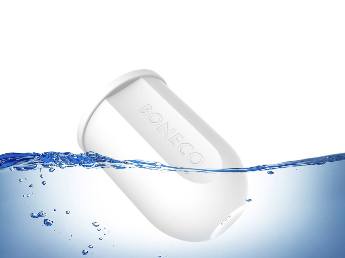 Ein weißer Wasserfilter taucht zur Hälfte in klarem, spritzendem Wasser. Auf dem Filter steht 'BONECO' in großen Buchstaben.