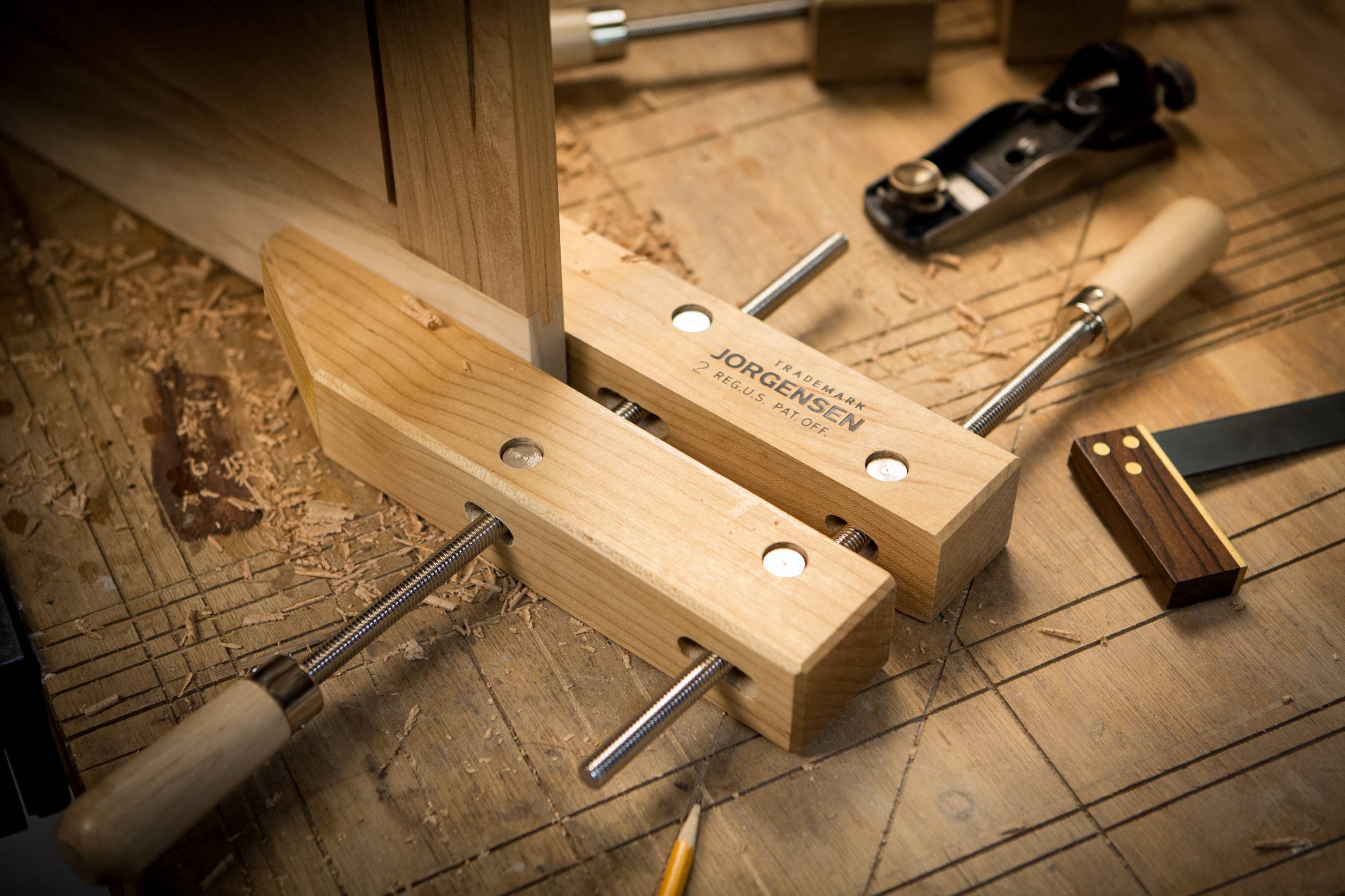 Holzwerkbank mit Schraubzwinge, Hobel und Bleistift; Werkzeuge und Materialien für Holzbearbeitung.