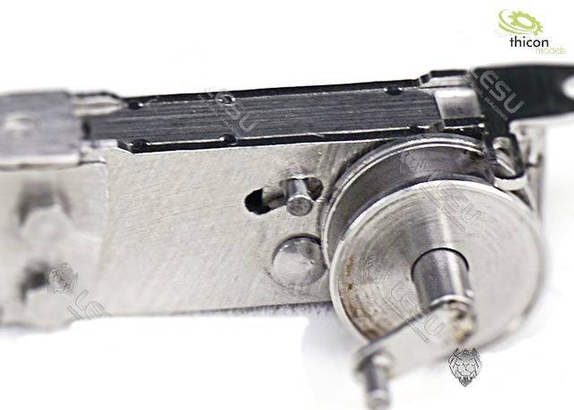 Nahaufnahme eines metallischen Zahnräder- oder Maschinenbauteils. Sichtbar sind Zahnräder und Metallverbindungsstücke auf weißem Hintergrund.