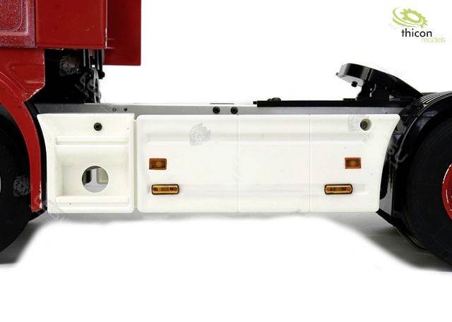 Weißes Modellfahrzeug-Chassis mit rotem oberen Teil und schwarzem hinterem Reifen, seitlich im Profil gezeigt. Markenlogo oben rechts.