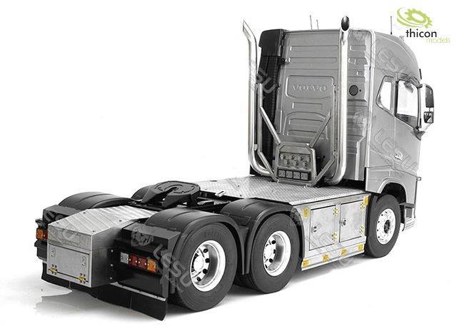 Ein silberner Lastwagen ohne Auflieger, seitliche Ansicht. Der LKW hat sechs Räder und ein robustes, modernes Design. Im Hintergrund ein Logo mit der Aufschrift 'thicon models'.