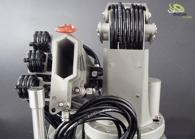 Industrie-Roboterarm mit Kabeln und Steuergerät, vor grauem Hintergrund.