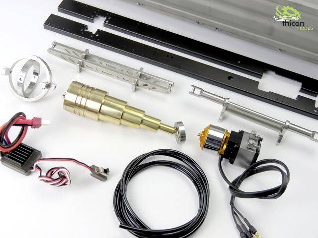 Ein Modellbau-Bausatz zeigt verschiedene Komponenten wie einen Elektromotor, Kabel, Metallteile und Halterungen auf weißem Hintergrund.