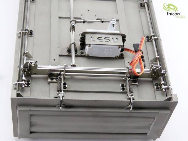 Metallrahmen-Konstruktion mit montiertem Servo, Kabeln und Gelenken, möglicherweise Teil eines Modellbauprojekts. Firmenlogo 'thicon model' sichtbar.