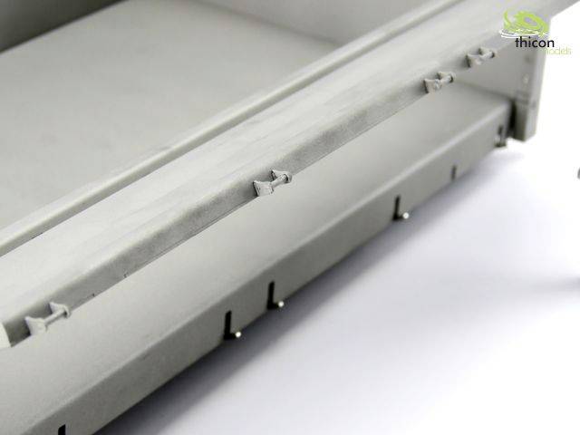 'Graue Modellbau-Komponente aus Kunststoff mit mehreren Haken und Einkerbungen, Teil eines größeren Systems.'
