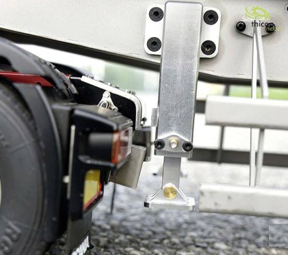 Nahaufnahme eines LKW-Rades und einer silbernen Stütze, die Teil eines Anhängers ist. Die Details des Materials sind erkennbar.