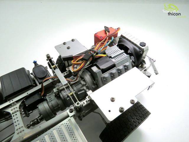 Detailaufnahme eines Modellfahrzeug-Chassis mit Verkabelung und Motor. Links Reifen, rechts Logo 'Thicon'. Studioaufnahme.