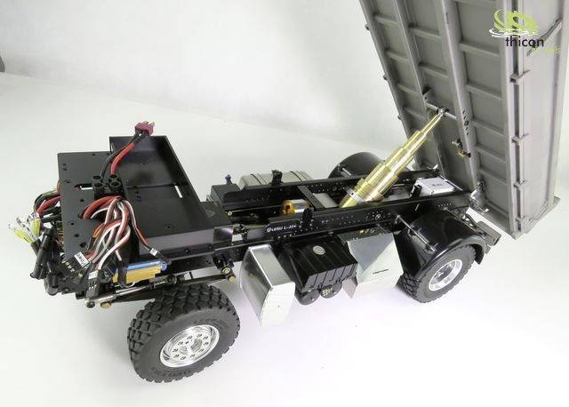Spielzeug-Lkw-Chassis mit angehobener Ladefläche, detaillierte Verkabelung und mechanische Teile sichtbar. Oberansicht.