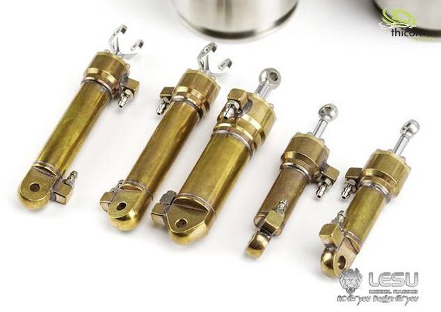 'Fünf goldene Metallzylinder mit Gelenken und Schrauben, auf einer weißen Oberfläche arrangiert. Technische Bauteile für Modellbau.'