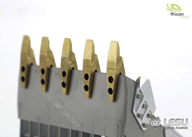 Silbernes Gerät mit goldenen, gezackten Spitzen in einer Reihe, möglicherweise Teil eines größeren mechanischen Modellsystems.