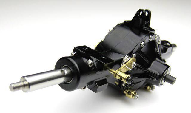Nahaufnahme eines schwarzen mechanischen Geräts mit Metallbolzen und Zahnrädern, wahrscheinlich ein Getriebe oder Motorbestandteil.