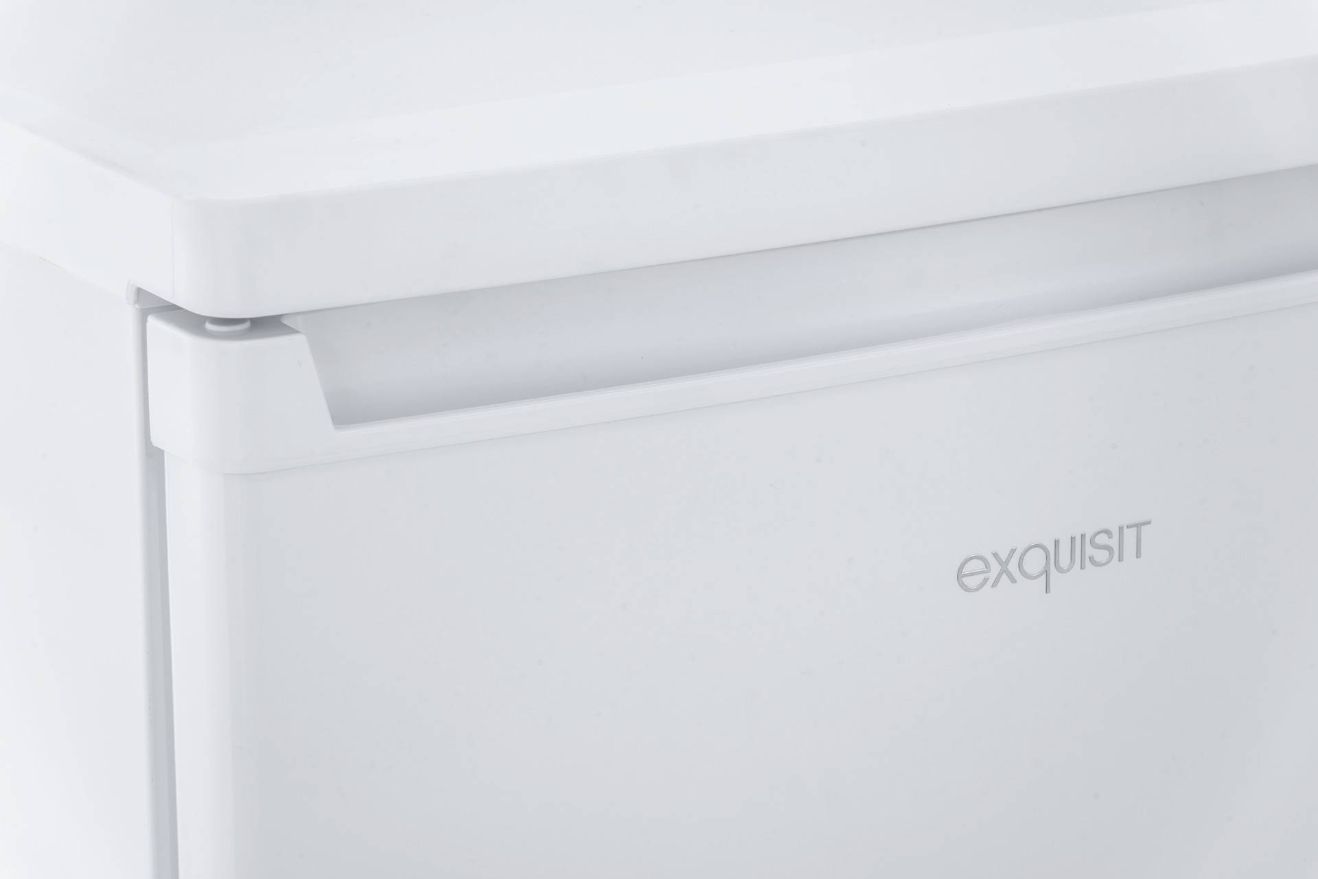 Teilansicht eines weißen Haushaltsgeräts mit der Aufschrift 'exquisit', möglicherweise ein Kühlschrank oder eine Tiefkühltruhe.