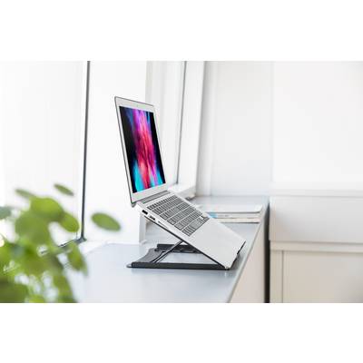 Ein Laptop steht auf einem verstellbaren Ständer auf einer Fensterbank. Der Bildschirm zeigt bunte, unscharfe Farben.