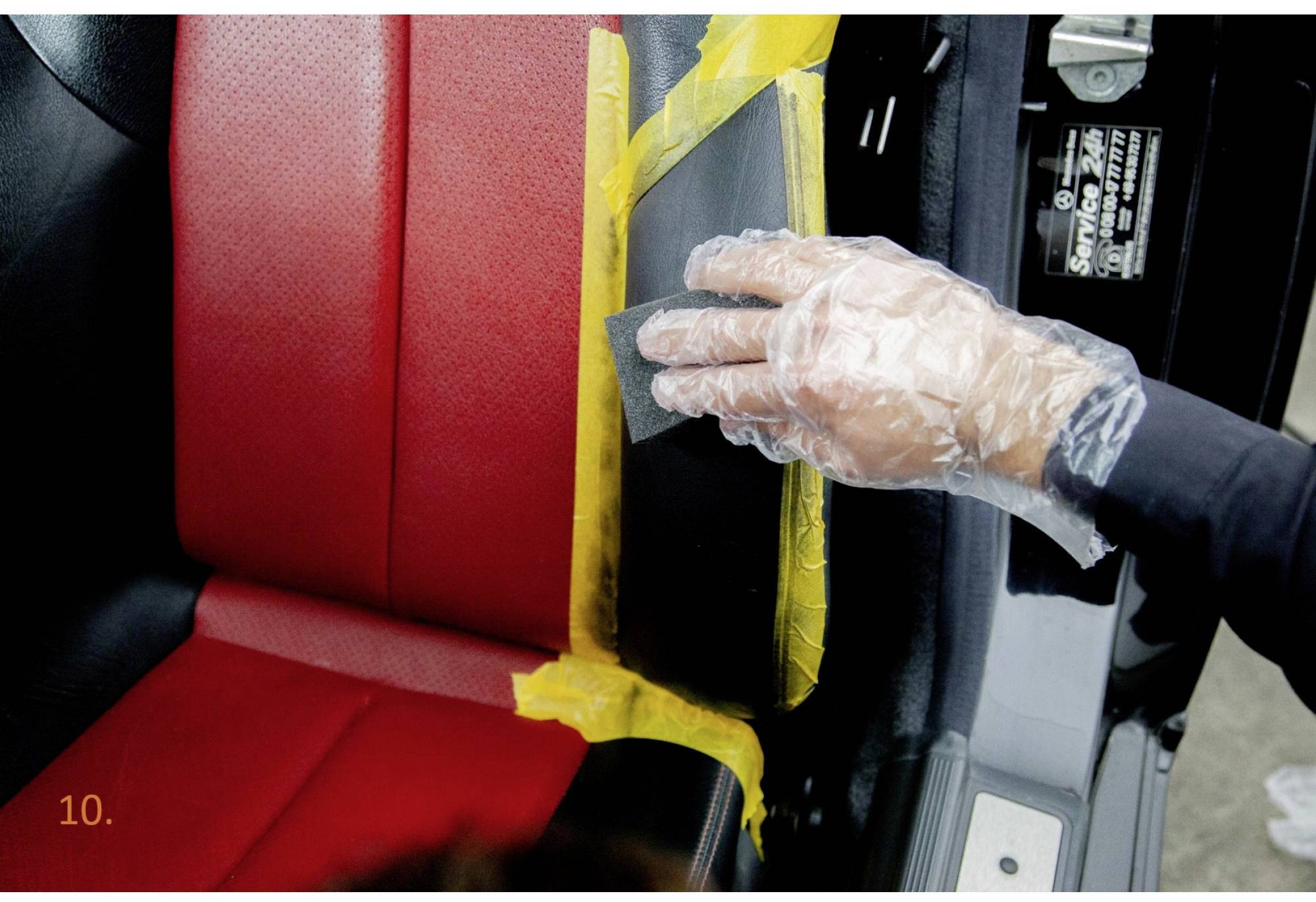 Eine Person trägt einen Plastikbeutel über der Hand und schleift ein mit Klebeband geschütztes Teil eines Autositzes.