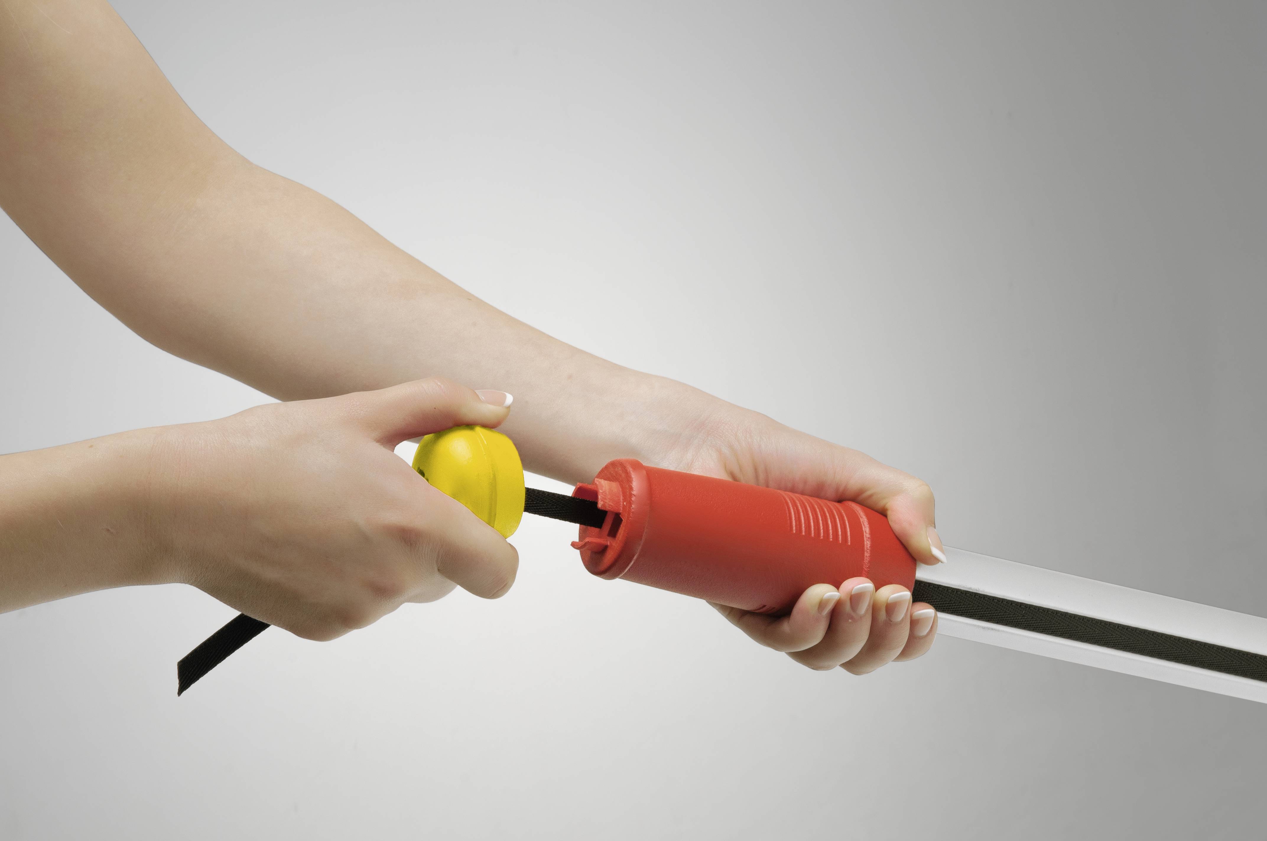 Eine Person hält einen langen, rot-gelben Plastikinflator und pumpt damit einen rechteckigen, transparenten Gegenstand auf.