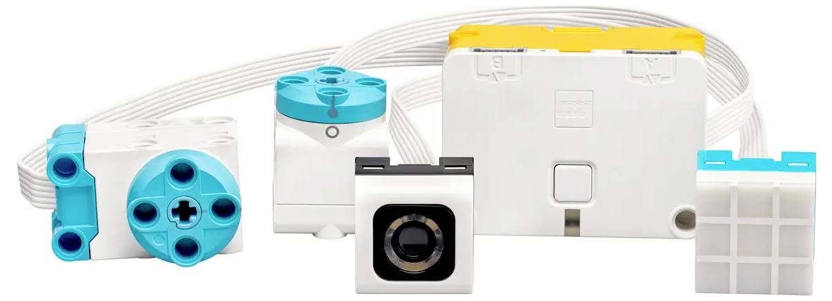 Mehrere weiße und blaue Steckverbindungen und ein gelbes Bauelement sind nebeneinander angeordnet, verbunden durch Kabel.