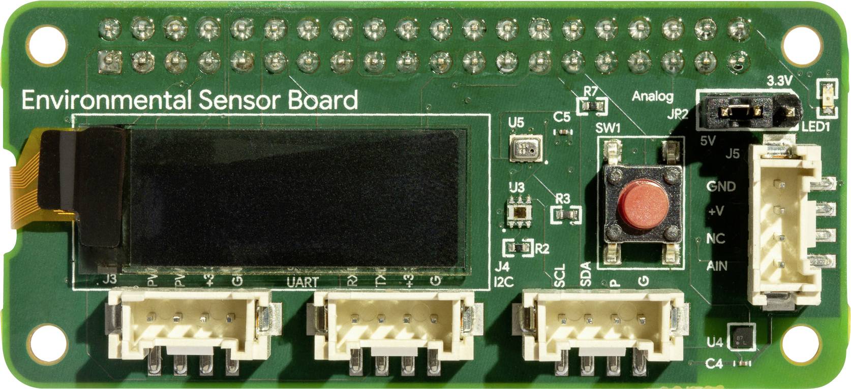 Umweltmesssensorplatine mit Display, Tasten und mehreren Anschlussports, bezeichnet als 'Environmental Sensor Board'.