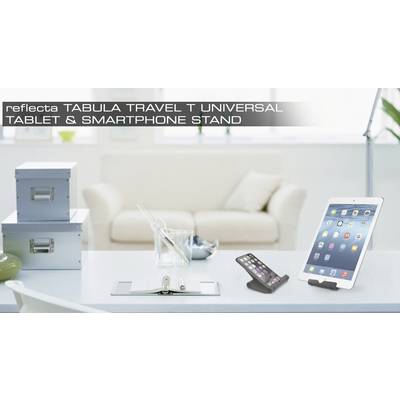 Auf einem Schreibtisch stehen ein Smartphone und ein Tablet auf Ständern. Im Hintergrund sind ein Sofa und Kisten zu sehen.