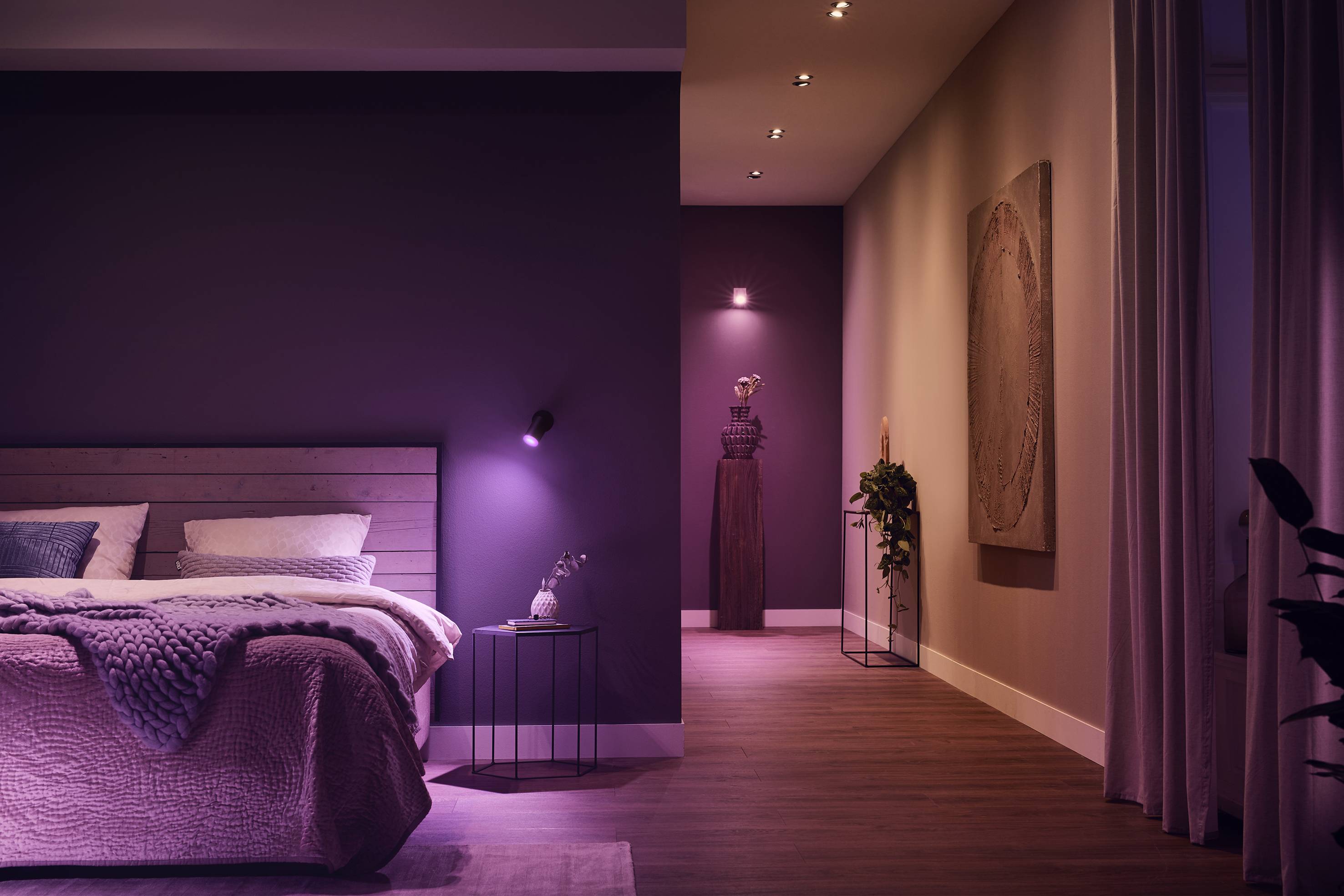 Ein stilvoll eingerichtetes Schlafzimmer in warmen Tönen mit einem modernen Bett, Nachttisch und dezenter Beleuchtung für entspannte Atmosphäre.
