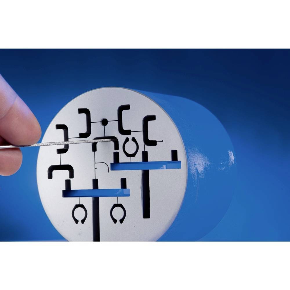 Ein Rundzylinder mit eingeschlitzten Formen für Lockpicking-Übung, gehalten von einer Hand vor einem blauen Hintergrund.