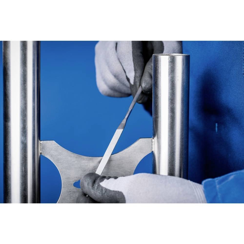 Eine Person in blauer Kleidung arbeitet mit Handschuhen und einem Werkzeug an einer Metallstruktur vor blauem Hintergrund.