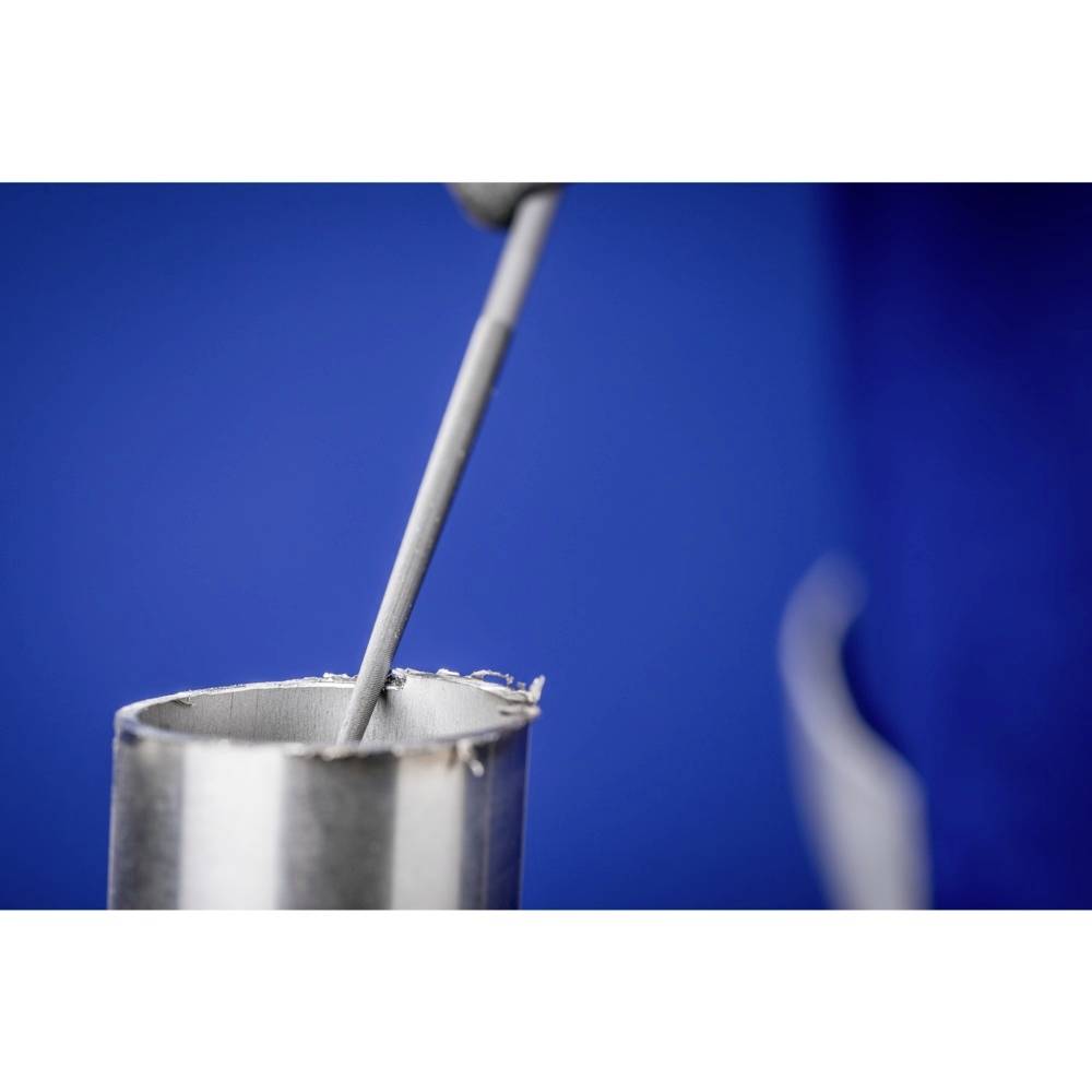 Ein Metallstab wird in ein zylinderförmiges Metallgefäß getaucht. Der Hintergrund ist blau. Experimentelle Laborumgebung.