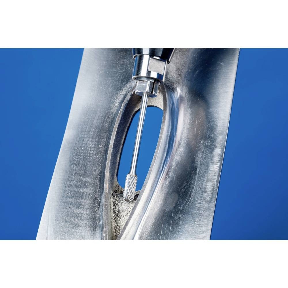 Ein Fräswerkzeug bearbeitet präzise eine Metalloberfläche mit einer ovalen Aussparung auf blauem Hintergrund.